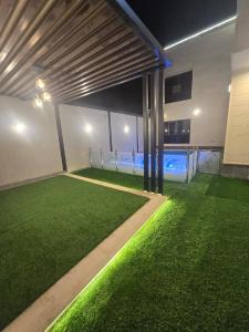 a room with green grass and a swimming pool at شالية ورد in Rayyis