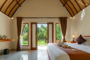 a bedroom with a large bed and a large window at The Kaci Penida By Bali Cabin in Nusa Penida