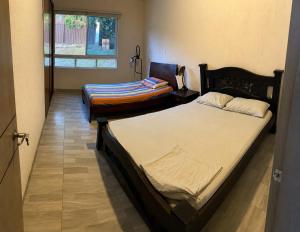 two twin beds in a room with a window at Finca El Balmoral in Tocaima +8 photos