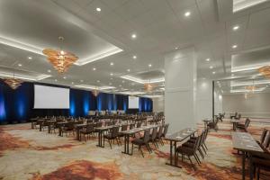 a conference room with tables and chairs and a screen at The Westin Cleveland Downtown in Cleveland