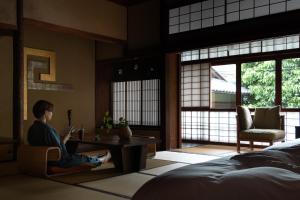 a person sitting on a chair in a room at Sowaka in Kyoto