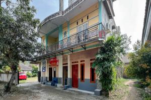 a building with a balcony on top of it at Homestay E Rahayu Anyer RedPartner in Serang