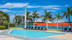 a swimming pool with chaise lounges and chairs next to the water at Holiday Inn Express - Tuxpan by IHG in Tuxpan de Rodríguez Cano