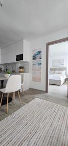 a white living room with a bed and a table at Nala Host - Maafushi Homes in Maafushi