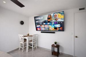 ein Wohnzimmer mit einem Fernseher an der Wand in der Unterkunft Modern Cozy Studio in Pinewood