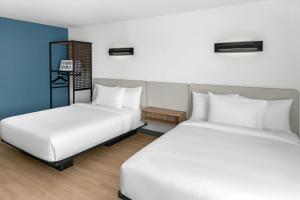 two beds sitting next to each other in a room at StudioRes by Marriott LaGrange in La Grange