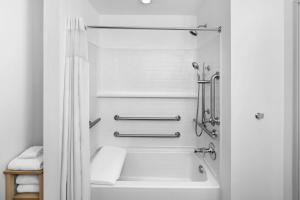 a white bathroom with a tub and a shower at StudioRes by Marriott LaGrange in La Grange +23 photos