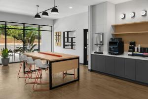 a kitchen with a wooden table and chairs at StudioRes by Marriott LaGrange in La Grange