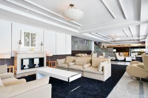 a living room with white furniture and a fireplace at Meliá Madrid Barajas in Madrid