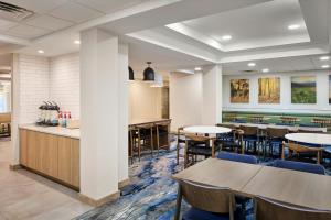 a dining area with tables and chairs in a cafeteria at Fairfield Inn & Suites Cleveland Avon in Avon