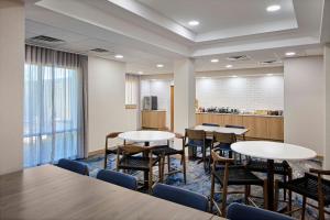 a room with tables and chairs and a kitchen at Fairfield Inn & Suites Cleveland Avon in Avon +8 photos