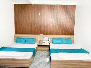 a room with two beds with blue pillows at Nhà nghỉ Lena Quan Lạn in Quan Lạn