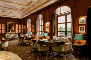 a hotel lobby with tables and chairs and windows at Hotel Fénix, a Gran Meliá Hotel - The Leading Hotels of the World in Madrid