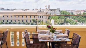 a table on a balcony with a view of a city at Hotel Fénix, a Gran Meliá Hotel - The Leading Hotels of the World in Madrid