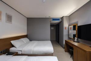 a hotel room with two beds and a flat screen tv at Insadong Crown Hotel in Seoul