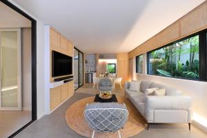a living room with a white couch and a table at Tree Villa Bangkok in Bangkok