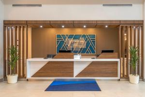 an office lobby with a reception desk with plants at Holiday Inn Express Breezewood by IHG in Breezewood +38 photos