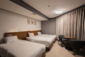 a hotel room with two beds and a table at Insadong Crown Hotel in Seoul +80 photos