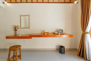a room with a counter with a stool and a mirror at The Kaci Penida By Bali Cabin in Nusa Penida