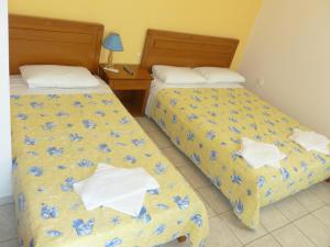 Dos camas en una habitación de hotel con flores azules en Peter & Tony Rooms, en Galissas
