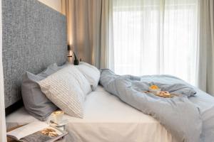 a bed with a blanket on it with a window at INNSiDE by Meliá Zaragoza in Zaragoza