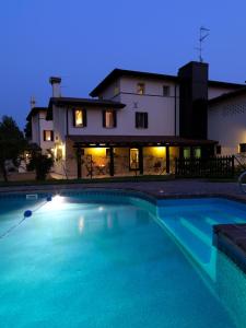 a swimming pool in front of a house at night at Ca' Dei Molini in Gruaro