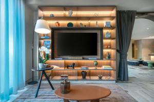 a living room with a television on a wall at AC Hotel Bologna by Marriott in Bologna