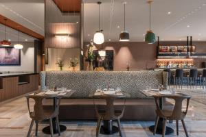 a restaurant with two tables and a bar at AC Hotel Bologna by Marriott in Bologna