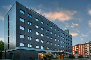 a large gray building in a city at AC Hotel Bologna by Marriott in Bologna