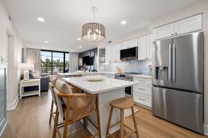 a kitchen with a stainless steel refrigerator and cabinets at Ocean Side Beach Condo in Ocean City