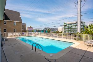 a swimming pool with a fence and a building at Ocean Side Beach Condo in Ocean City