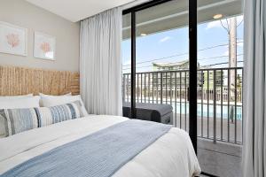 a bedroom with a bed and a balcony at Ocean Side Beach Condo in Ocean City +34 photos