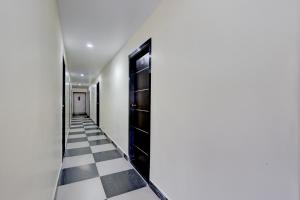 a hallway with a black and white checkered floor at Hotel O Satyam Junction Seethammadhara in Visakhapatnam