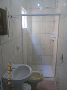 a bathroom with a shower and a toilet and a sink at Apartamento na Praia de Enseada in São Francisco do Sul