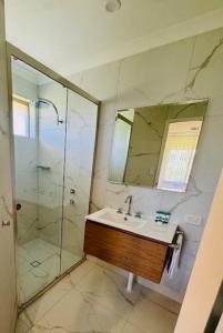 a bathroom with a sink and a shower with a mirror at Sittella's Vineyard Residence in Herne Hill +8 photos