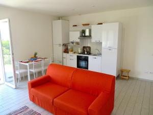 a living room with a red couch and a kitchen at Africa in Stresa