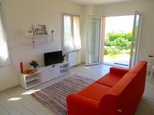 a living room with a red couch and a television at Africa in Stresa
