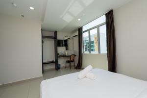 a hotel room with two beds and a window at Swing & Pillows - Klebang, Melaka in Malacca