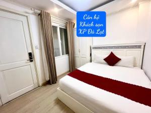 a bedroom with a bed with a sign on the wall at Khách Sạn Căn Hộ XP -Đà Lạt in Da Lat