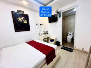 a bedroom with a white bed and a bathroom at Khách Sạn Căn Hộ XP -Đà Lạt in Da Lat
