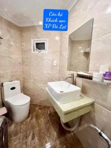 a bathroom with a sink and a toilet and a mirror at Khách Sạn Căn Hộ XP -Đà Lạt in Da Lat
