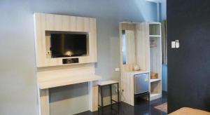 a room with a tv on a wall at The Nest Hotel in Sathani Phu Khao Lat