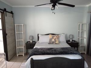 a bedroom with a bed with a ceiling fan at Perdekuil in Stilbaai-Wes