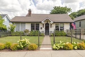 a white house with a fence and an american flag at Nashville Fatherland Cottage in Nashville
