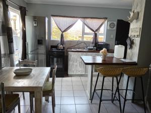 a kitchen with a table and a table and chairs at Perdekuil in Stilbaai-Wes