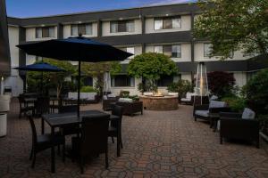 a patio with tables and chairs and an umbrella at Courtyard Hartford Cromwell in Cromwell