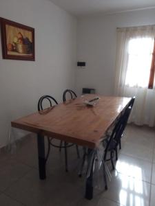 a wooden table with chairs in a room at Cabañas moye in Santa Rosa de Calamuchita