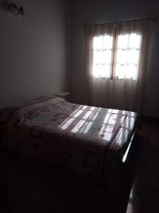 a bed in a dark room with a window at Cabañas moye in Santa Rosa de Calamuchita