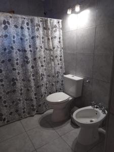 a bathroom with a toilet and a shower curtain at Cabañas moye in Santa Rosa de Calamuchita