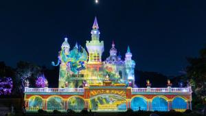 a disney castle is lit up at night at Castfast Hotel in Dongguan